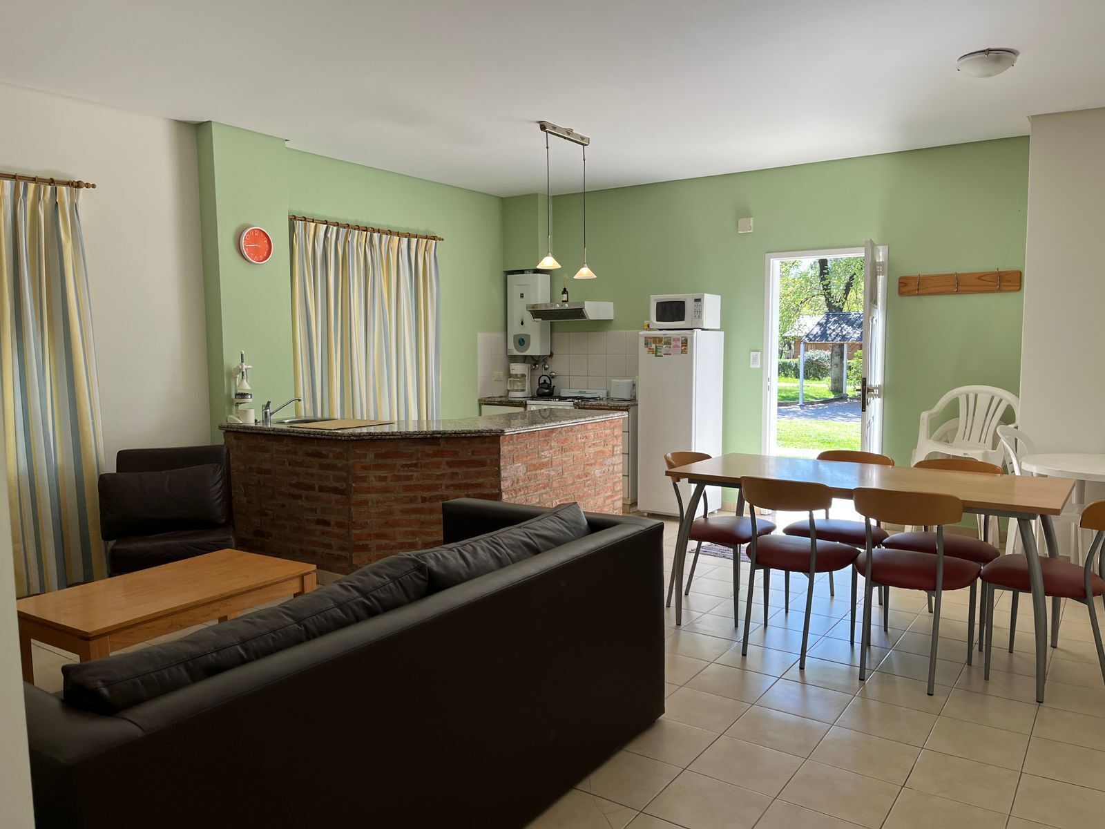 Un espace de vie compact comprenant une cuisine, un coin repas et un espace détente.