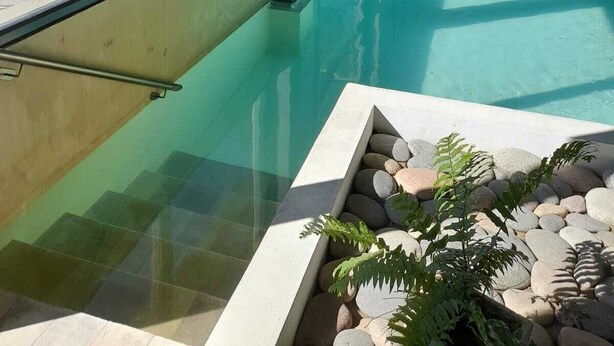 A swimming pool area with clear glass walls and a view of the outdoors. - Los Robles Apart Hotel (Sierra de la Ventana)
