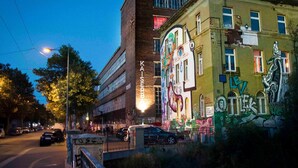 Ein Gebäude mit Graffiti und einer Uhr an der Fassade.