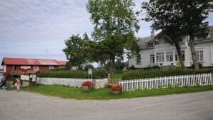 A building with a red roof and a white fence in front. - Handelsstedet Forvik (Vevelstad)