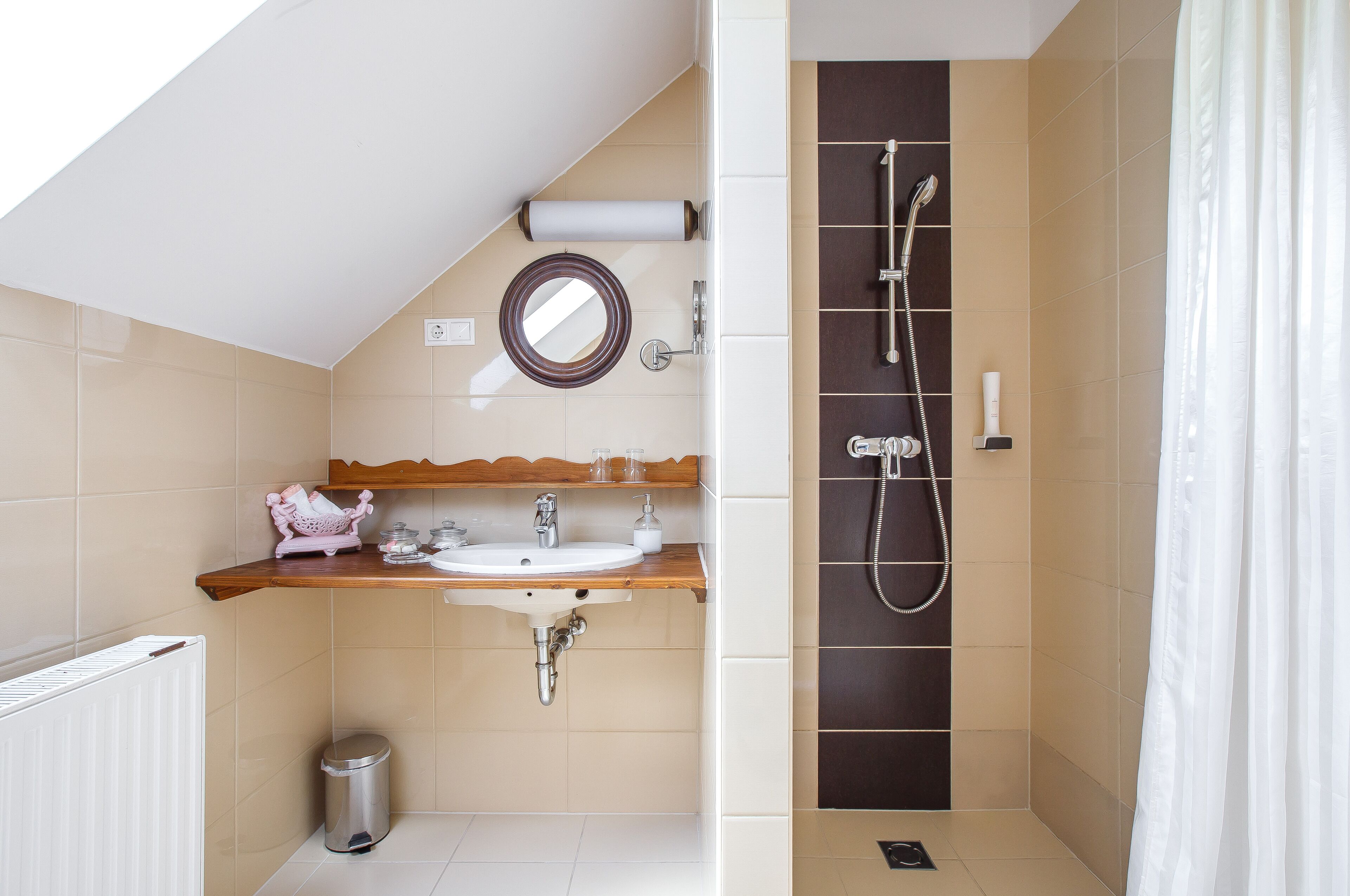A modern bathroom with a sink, mirror, and shower.