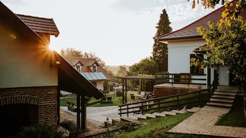 Un patio con chimenea de ladrillo, asientos al aire libre y una escalera que lleva a una zona cubierta.