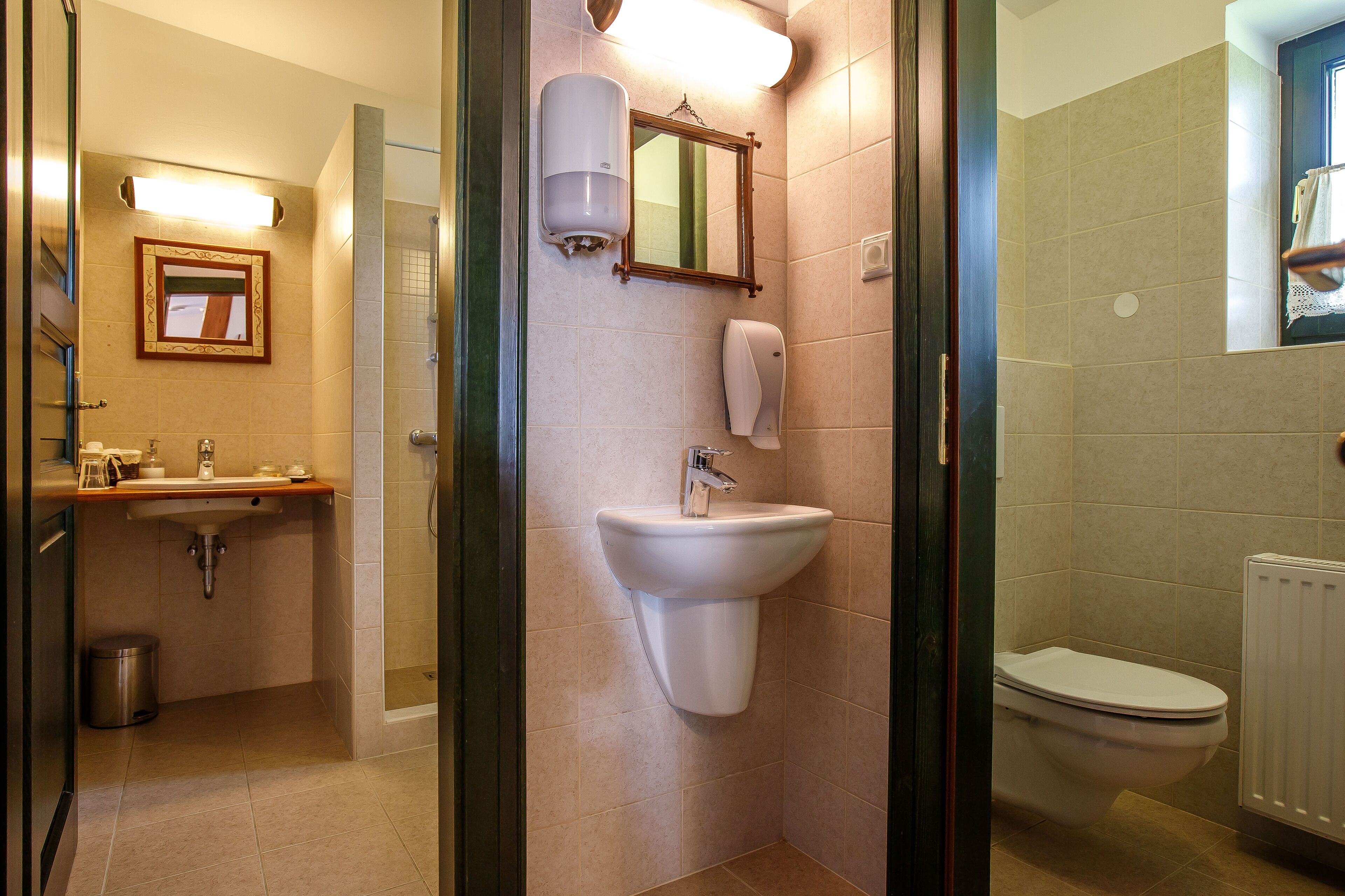 Et badeværelse med vask, spejl og toilet.