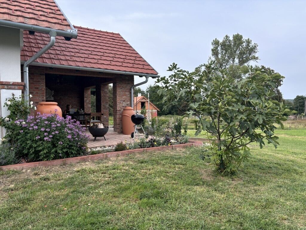 Una casa con fachada de ladrillo, tejado de tejas y un porche cubierto.