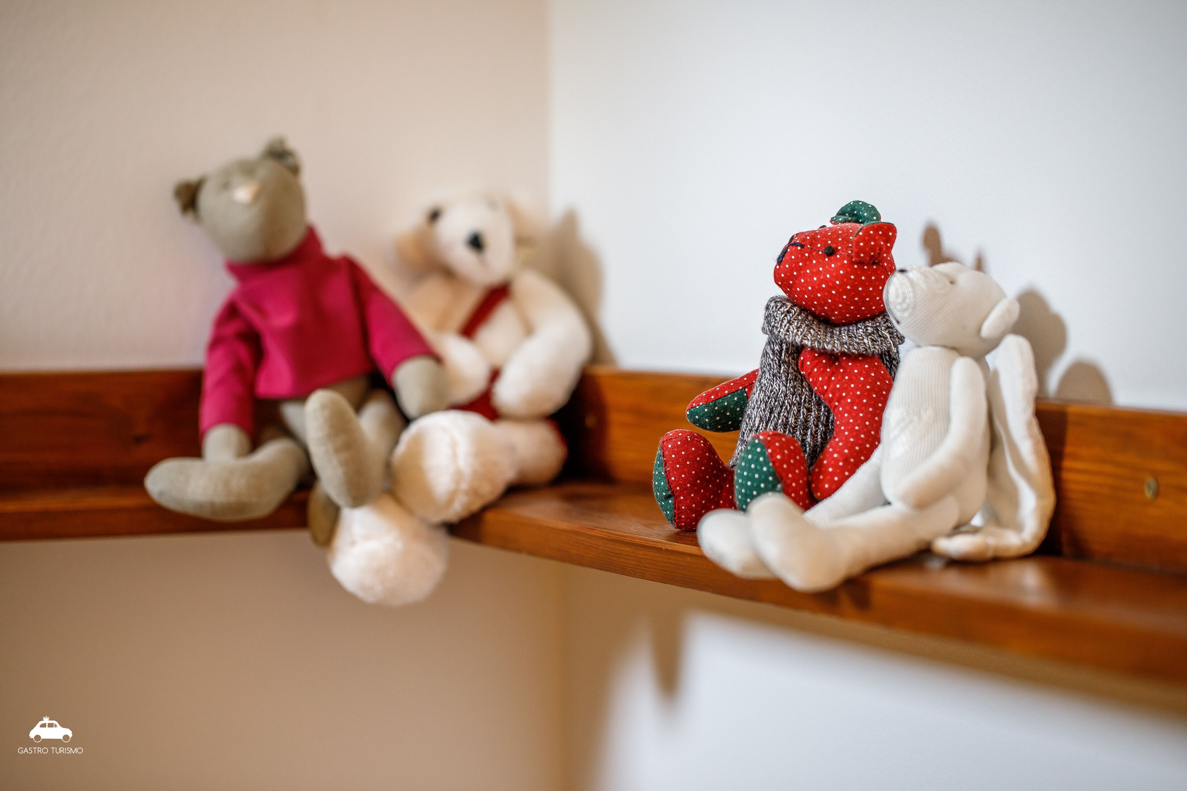 A wooden shelf with three plush toys.