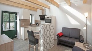 A compact living space with a kitchenette, a dining area, and a seating area. - Wohnung Bucki (Borkum)