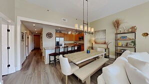 Una cocina moderna con armarios de madera, una isla central y un comedor con banco y sillas.