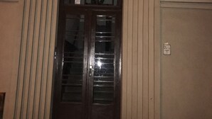 A building entrance with a large wooden door, a sign indicating room number 6, and a small sign with a number 50. - Dream Apartments Rzeszowska (Kraków)