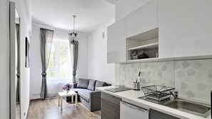 A modern kitchen with a built-in dishwasher, a sink, and a countertop with a wire basket. - Dream Apartments Rzeszowska (Kraków)