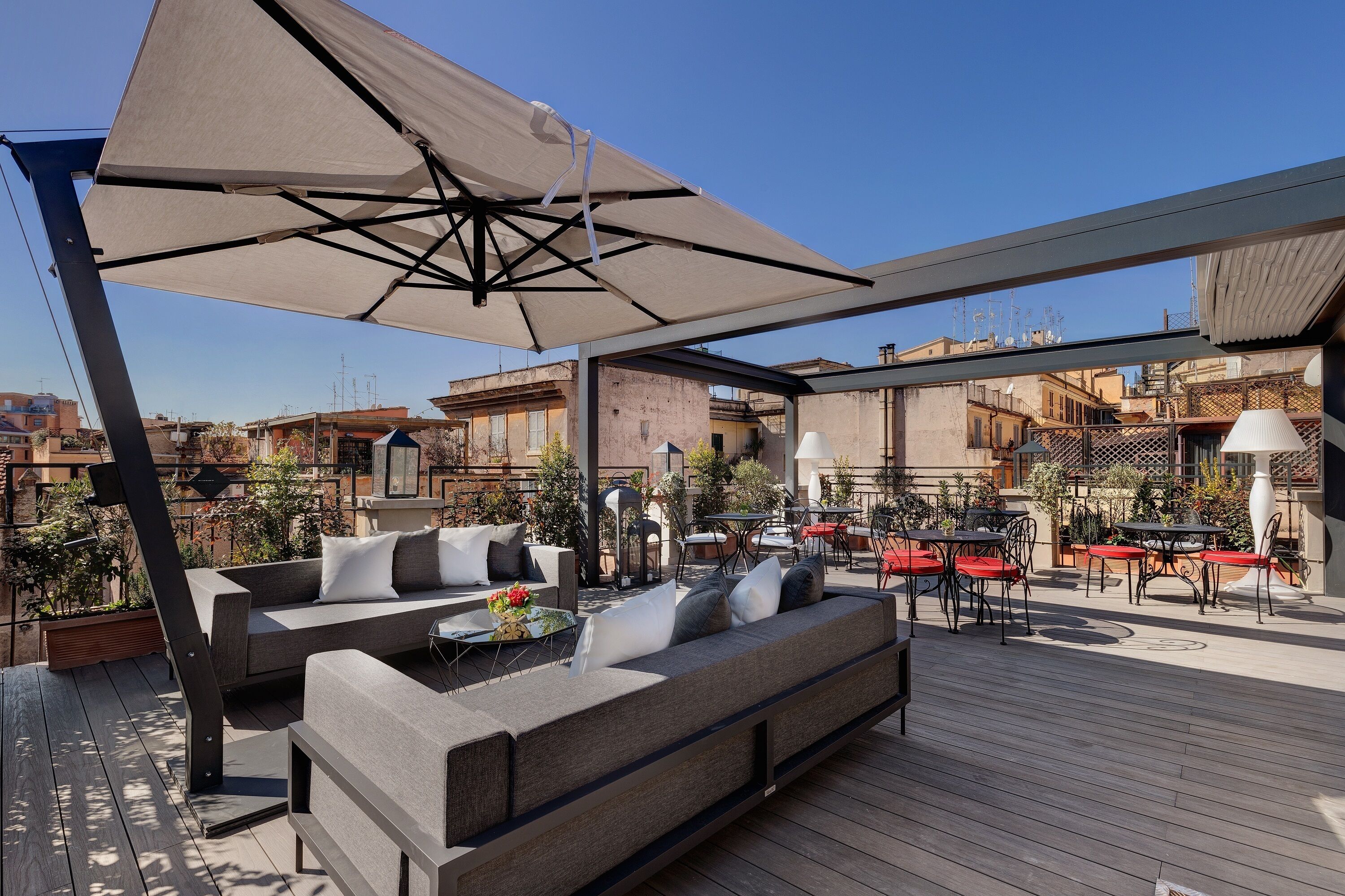 An outdoor patio with a sofa, tables, and umbrellas.