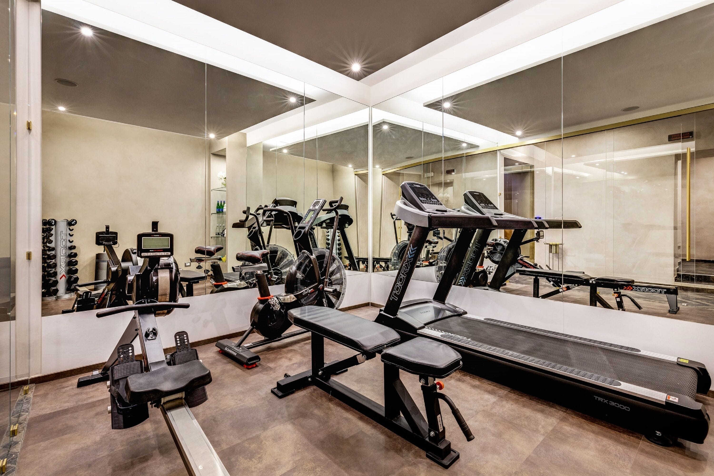 A gym with various exercise equipment, including treadmills, stationary bikes, and weight machines.