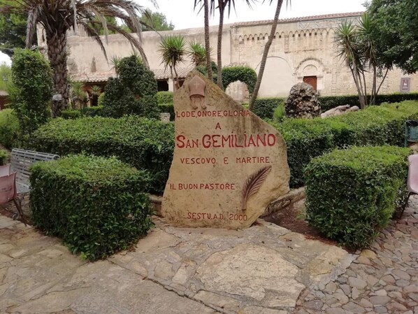 A stone monument with inscriptions in a garden setting. - Relaxing Home. (Sestu)