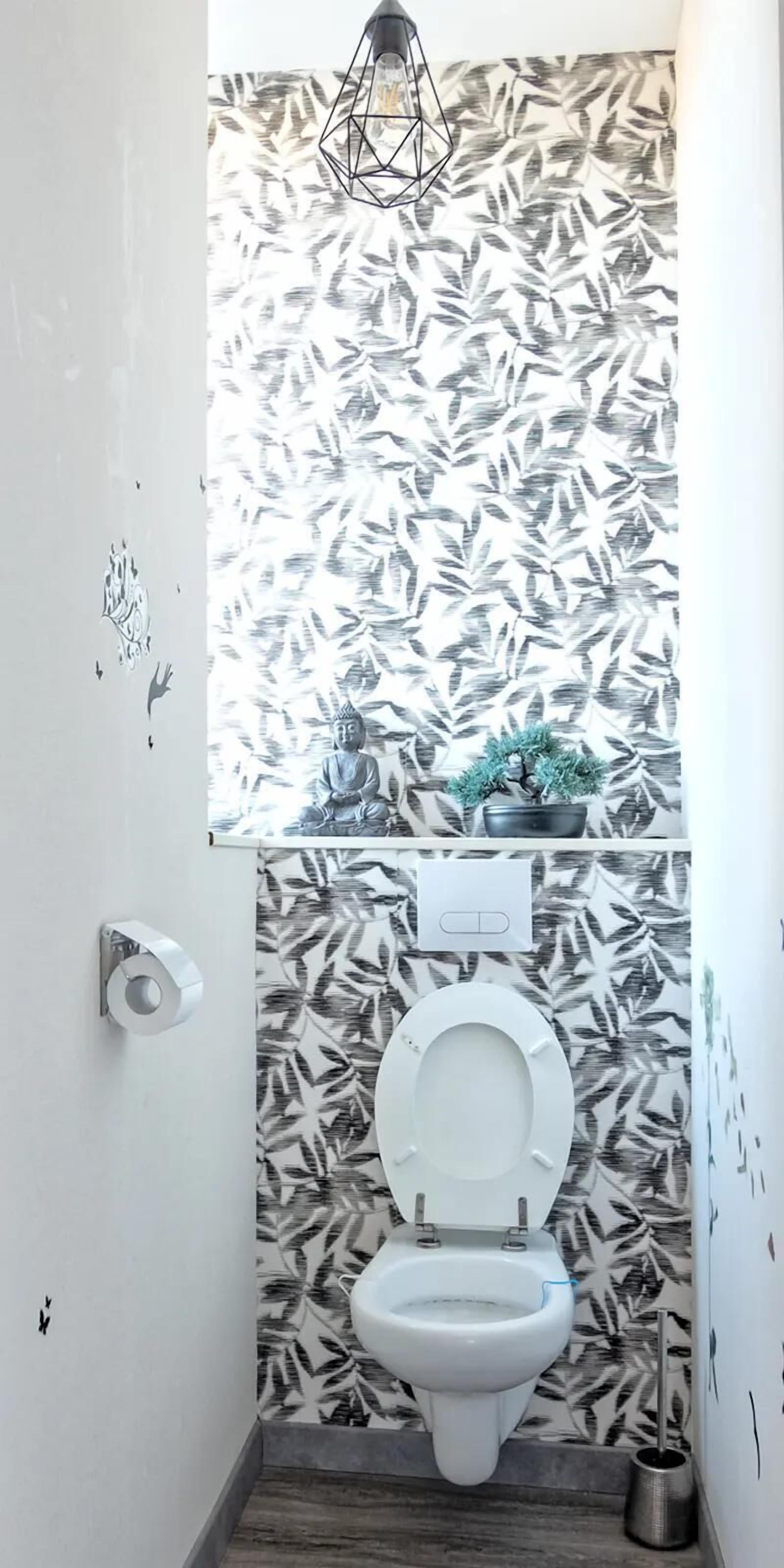 Une salle de bain équipée de toilettes, d’un bidet et d’un porte-rouleau de papier toilette fixé au mur.