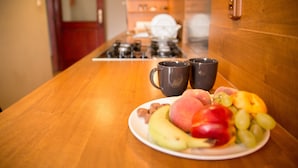 A kitchen counter with a plate of fruit and two mugs. - Filin Apartment (Kraków)