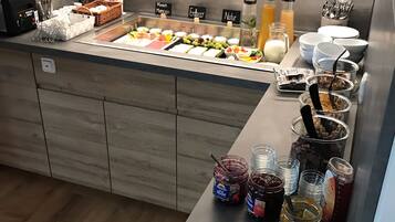 Balcão de buffet com diversos alimentos e acompanhamentos.