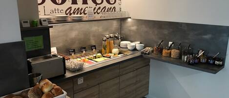 A breakfast buffet area with a coffee-themed wall, a variety of food options, and a coffee machine.