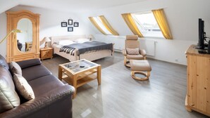 Une chambre à coucher moderne comprenant un lit, un canapé, une chaise, un bureau et une armoire.