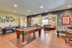 Enjoy games and relaxation in this spacious room featuring a pool table, foosball table, and billiards table.