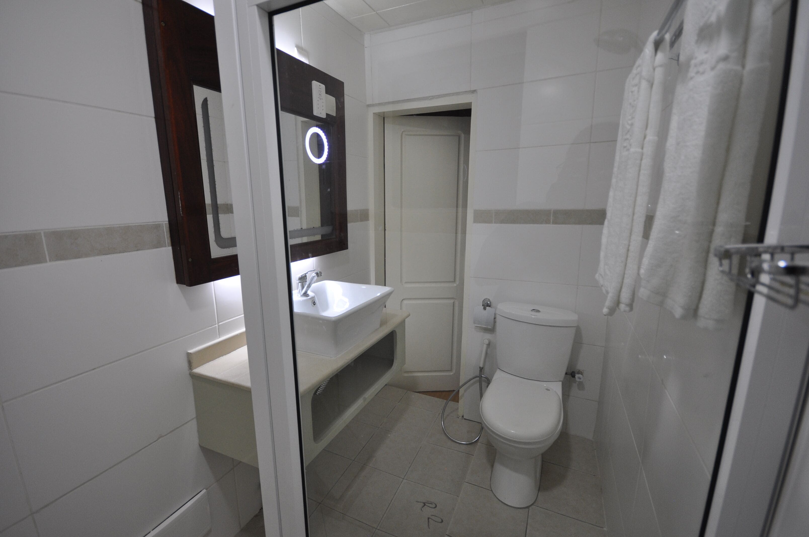 Un baño con lavamanos blanco, inodoro y zona de ducha.