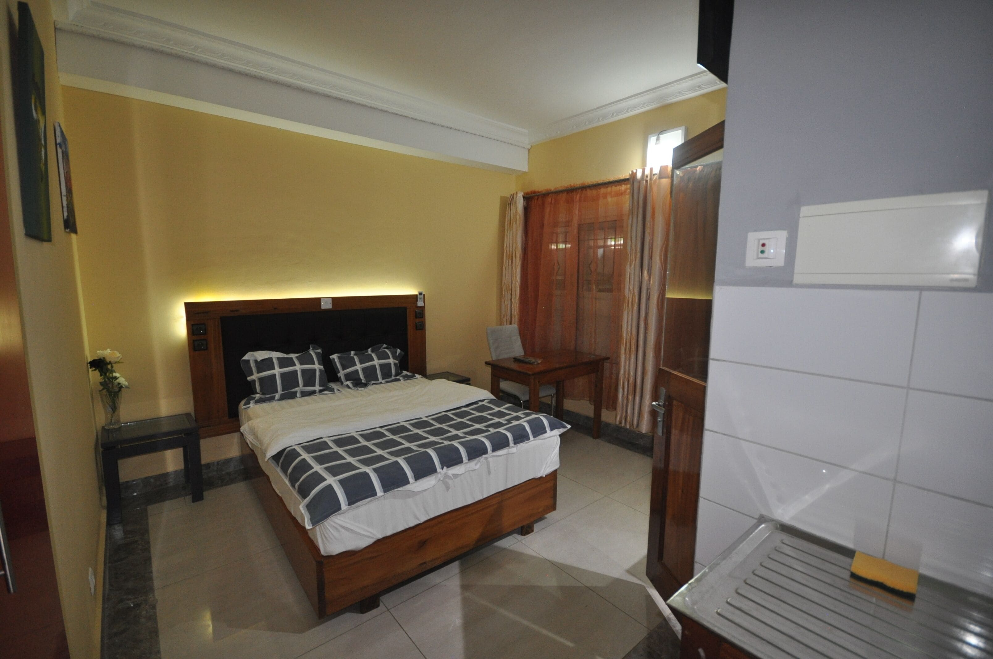 Un dormitorio con cama, mesita de noche y velador.