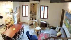 A dining area with a wooden table and chairs, a blue chair, a sofa, and a painting on the wall. - THE AERIE - THE EAGLE'S NEST - large apartment in strategic location (Siena)
