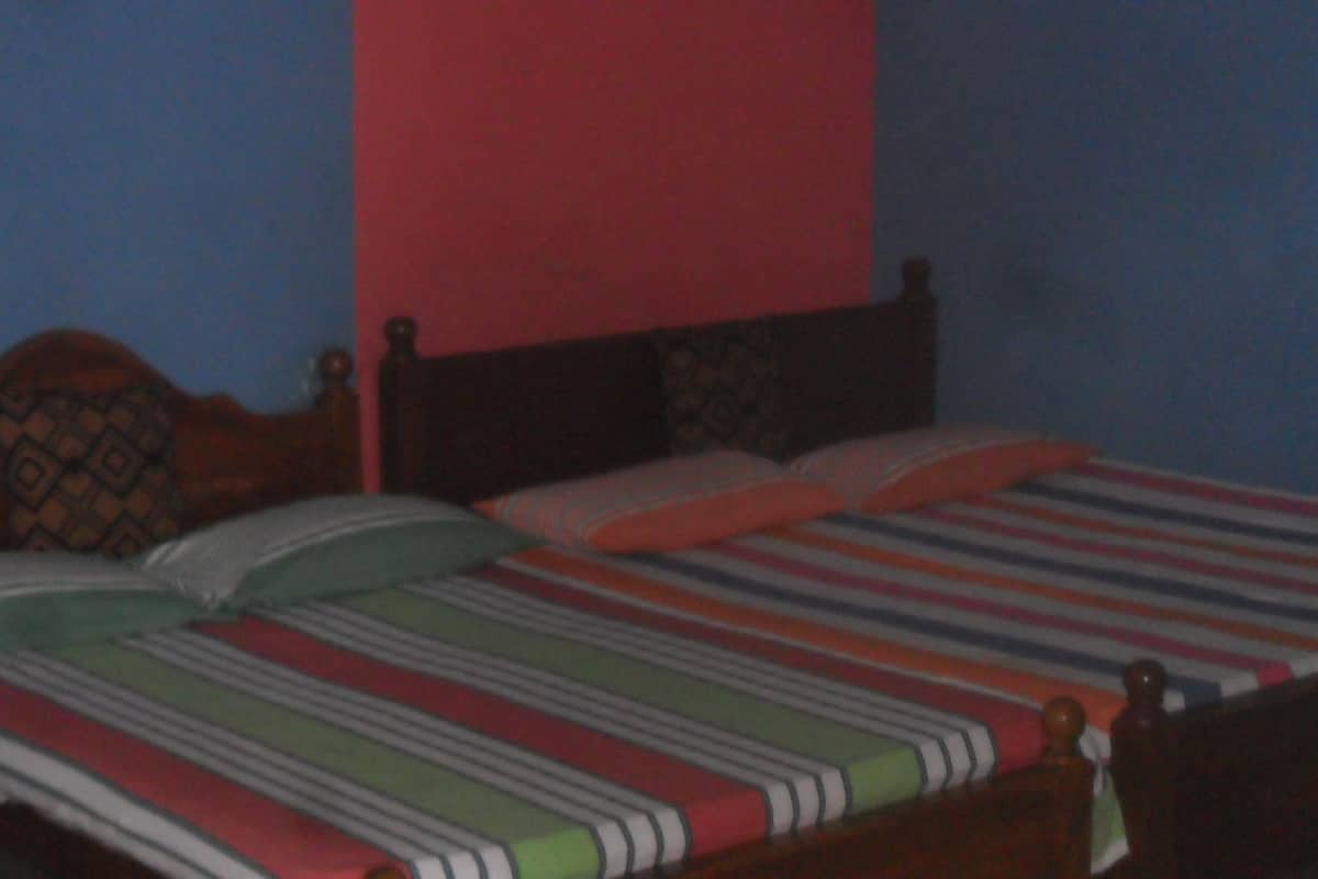 A bed with striped bedding and a wooden headboard.