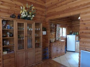 Ein Holzhütten-Interieur mit Küchenzeile, Holzausbau und Esstisch.