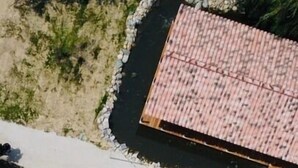 Vista aérea de un resort con piscina, zona de estar y un edificio de techo con tejas.