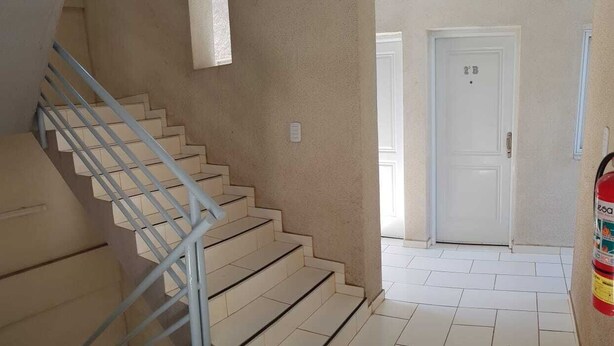 A staircase with a metal railing leading to a door marked "2B".