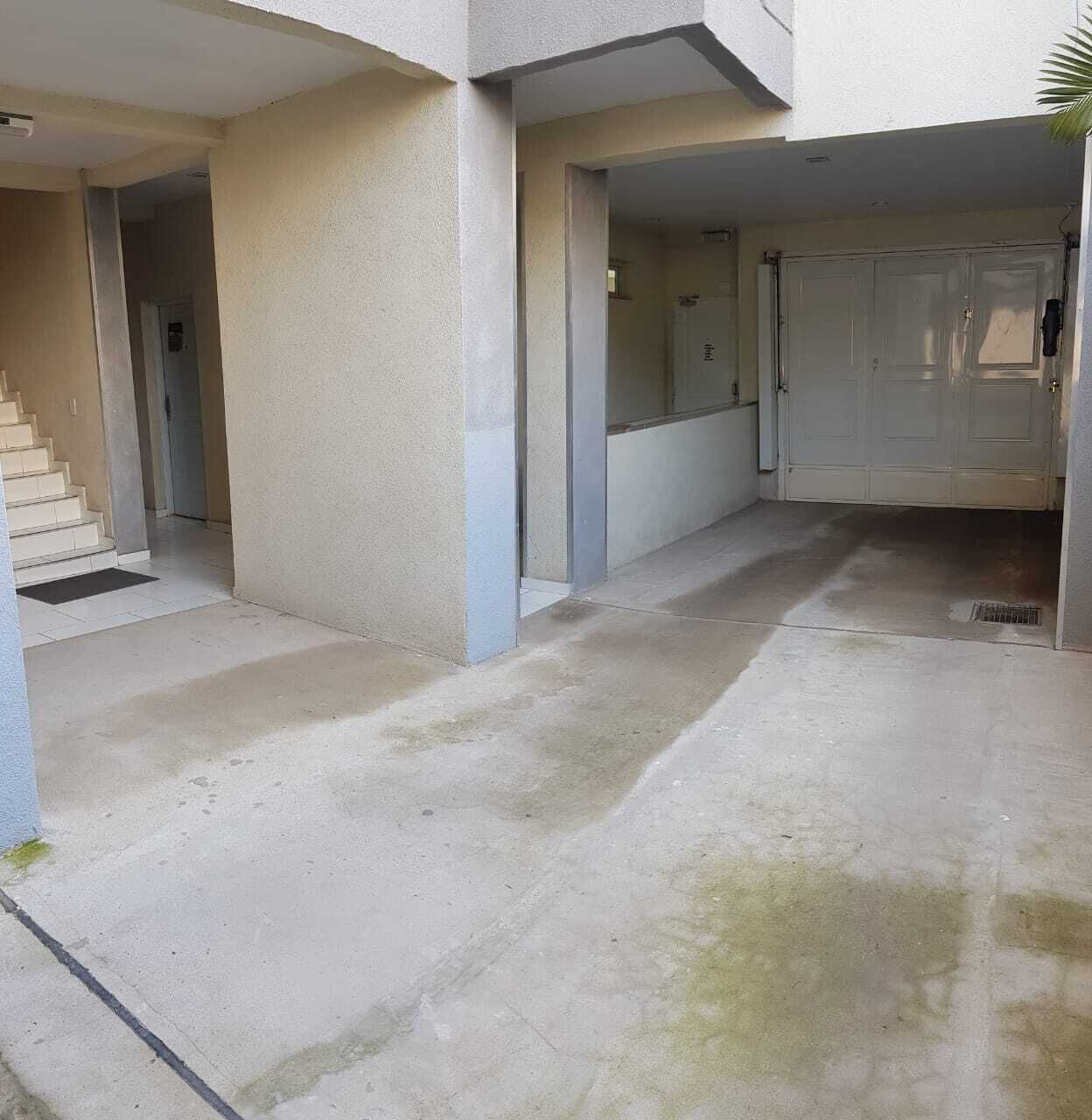 Un edificio con suelo de hormigón, una escalera y una puerta.