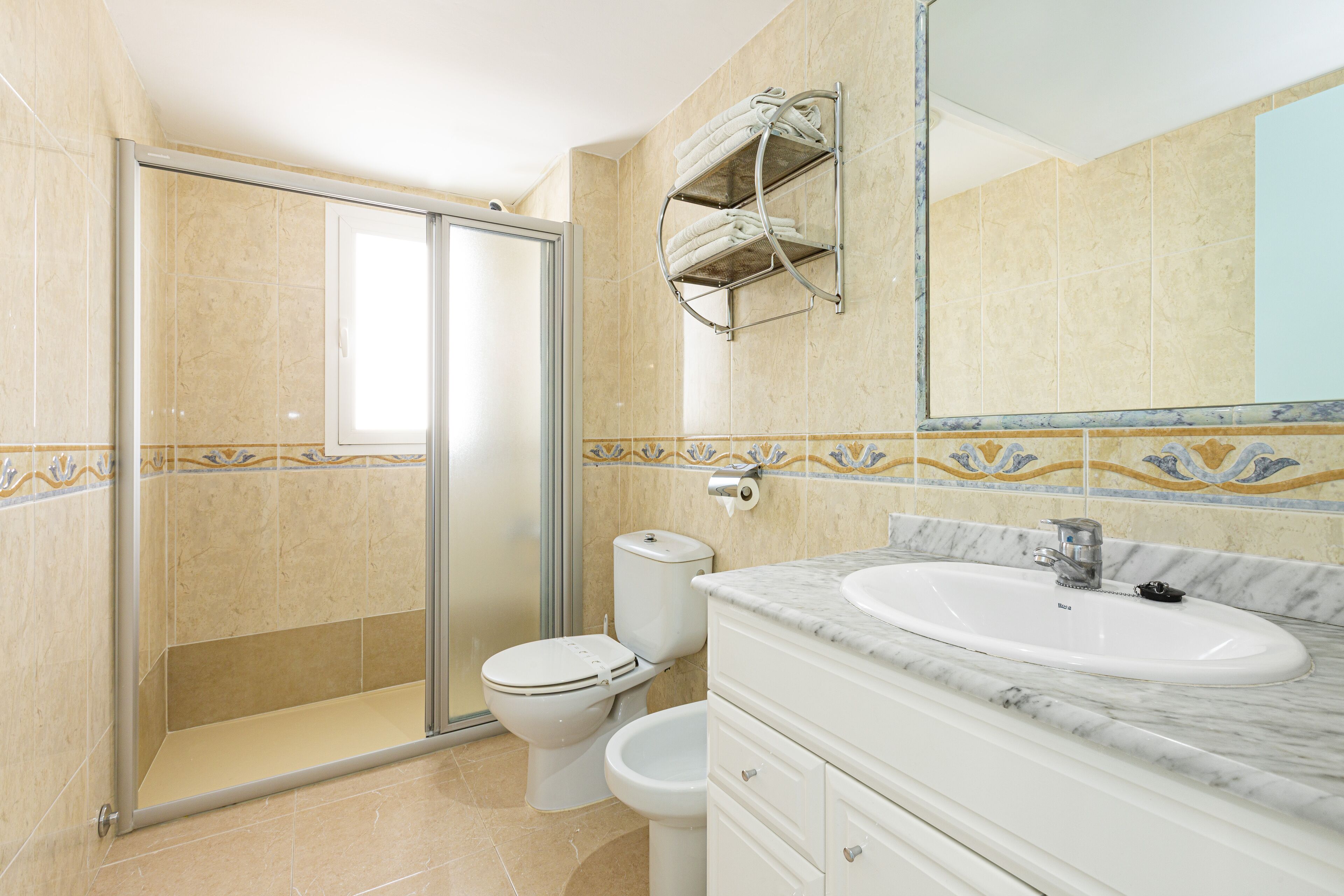A bathroom with a shower, toilet, and sink.