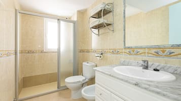 A bathroom with a shower, toilet, and sink.