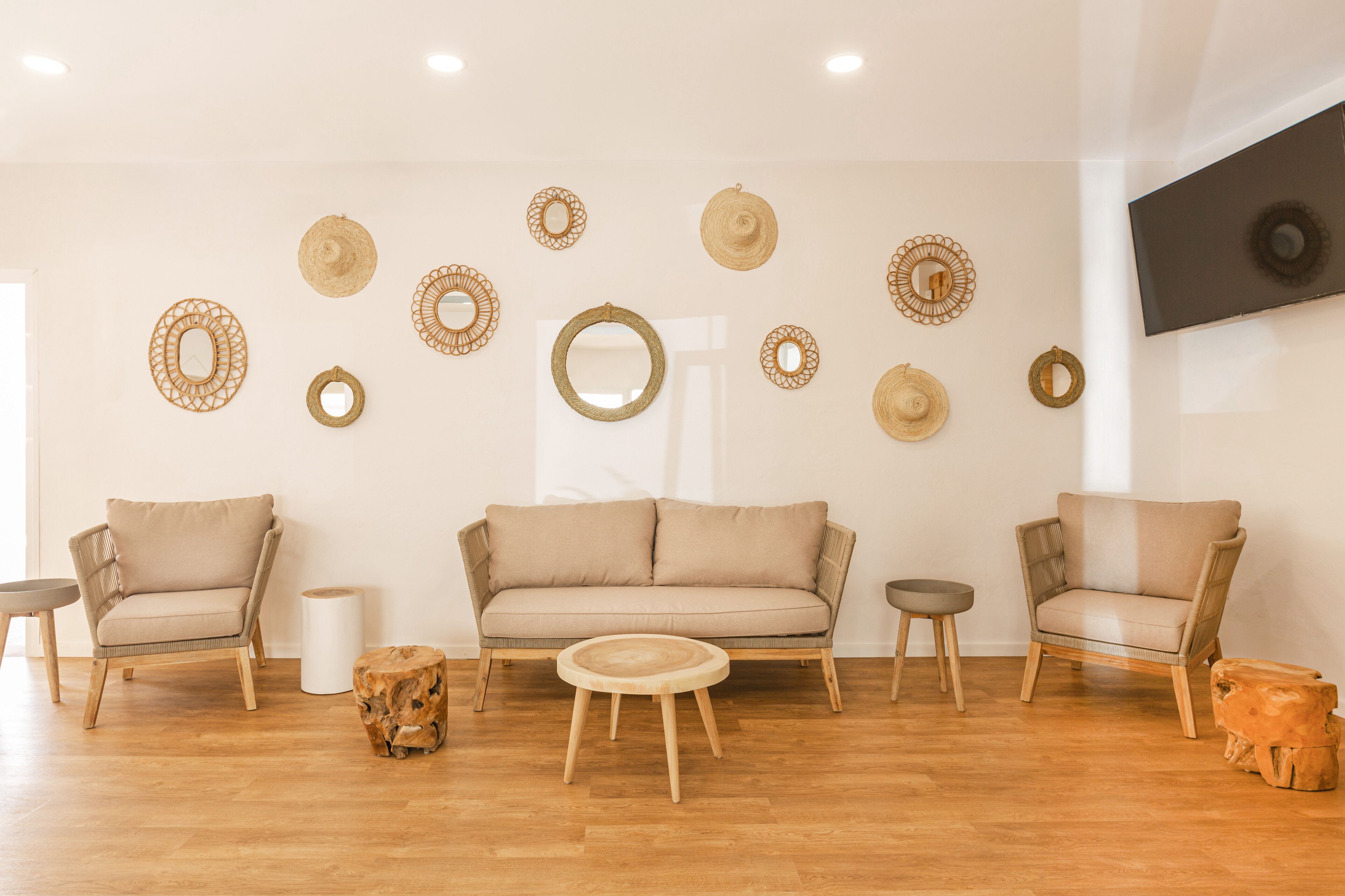 A modern living room with a beige sofa, two armchairs, a coffee table, and decorative wall art.