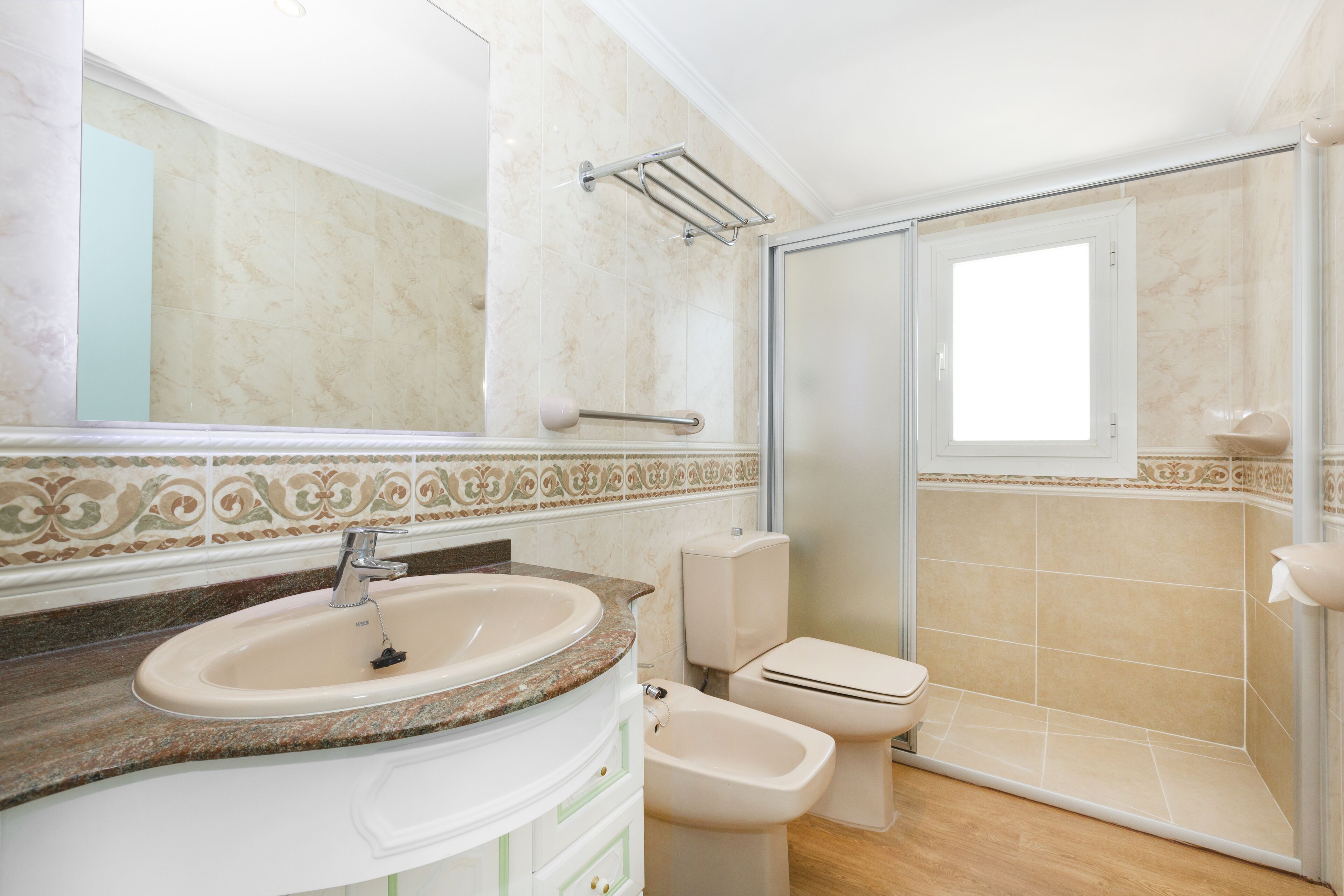 Un baño con lavamanos, inodoro, bidé y cabina de ducha de vidrio.