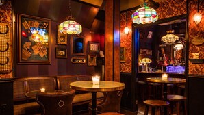 Un espace bar avec des meubles en bois, un comptoir et un éclairage décoratif.