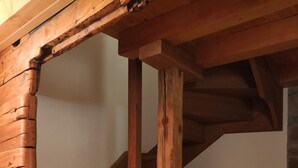 Un escalier en bois, de style rustique, menant à l’étage supérieur.