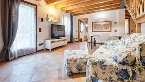 A cozy living room with a sofa, TV, and wooden ceiling beams. - Villa Navagero Erizzo - Ca' Rocchetto 2 (San Biagio di Callalta)