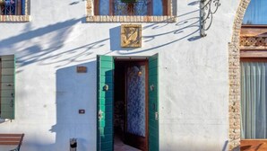 A building with a white facade, a green door, and a small window with a decorative frame. - Villa Navagero Erizzo - Ca' Rocchetto 2 (San Biagio di Callalta)