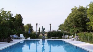 A rectangular pool with a clear blue water surface, surrounded by white lounge chairs and a statue in the center. - Villa Navagero Erizzo - Ca' Rocchetto 2 (San Biagio di Callalta)