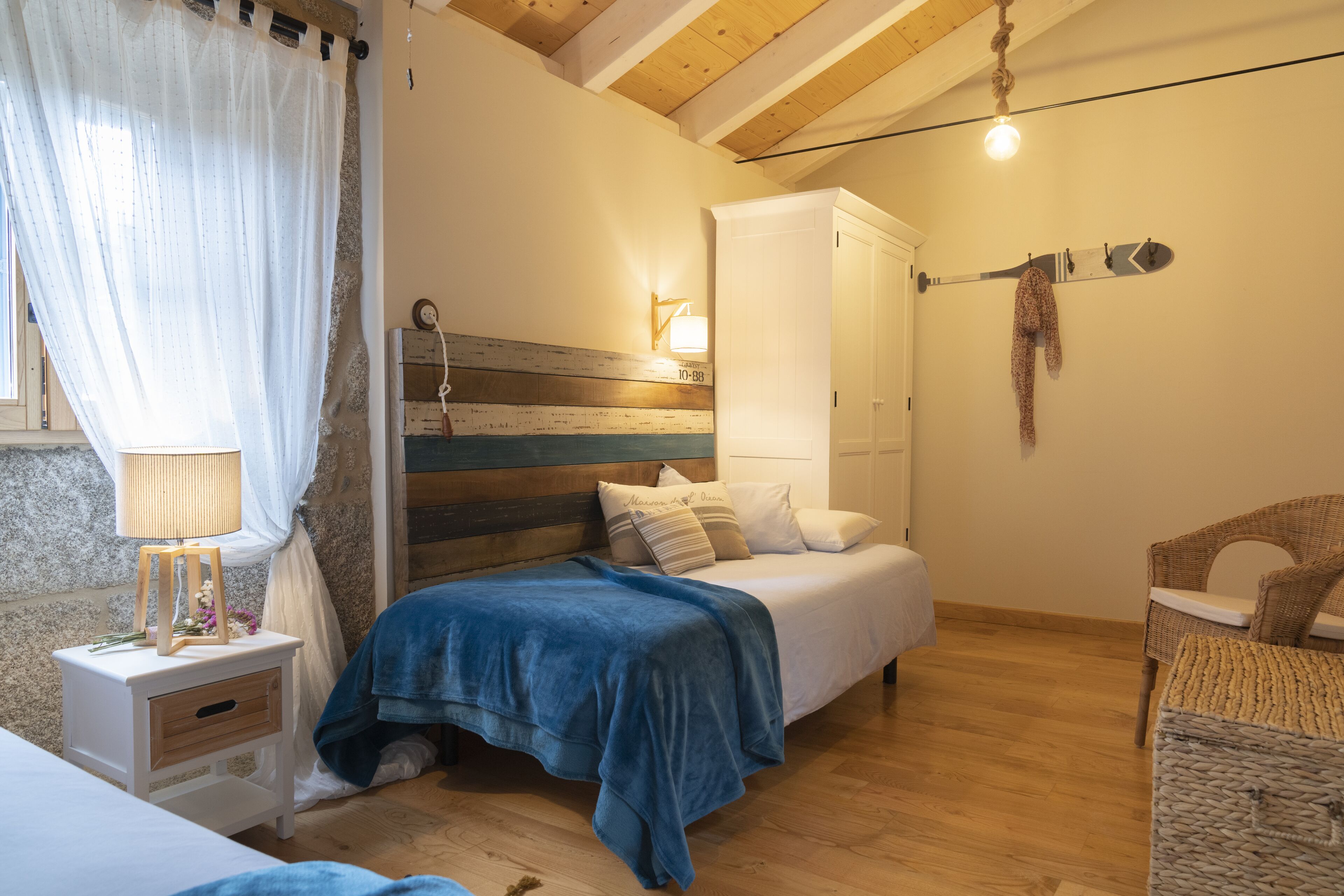 Un dormitorio con cama, mesita de noche, lámpara y armario.
