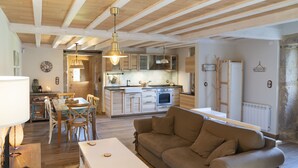 Un vaste espace de vie comprenant un canapé, une table à manger et une cuisine en arrière-plan.