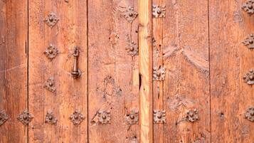 Una puerta de madera con cerrojos metálicos y un tirador central.