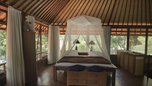 A bedroom with a canopy bed, wooden flooring, and large windows. - The Wantilan in Tejakula (Tejakula)