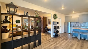Una cocina moderna con microondas integrado y un comedor con mesa y sillas de madera oscura.