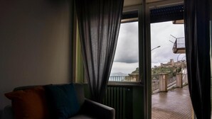 Una habitación con vista a un balcón y al paisaje urbano.