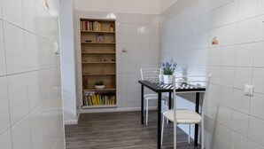 Un petit coin repas avec une table et des chaises, une bibliothèque et une plante en pot.