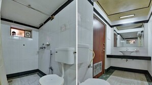 A bathroom with a toilet, sink, and mirror. - Pioneer Plaza Jodhpur (Jodhpur)