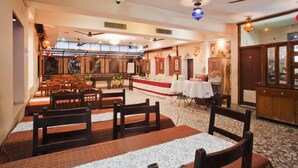 A restaurant with wooden furniture, a central dining area, and a bar. - Pioneer Plaza Jodhpur (Jodhpur)