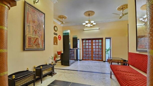 A hotel lobby with a reception desk, seating area, and a large painting on the wall. - Pioneer Plaza Jodhpur (Jodhpur)