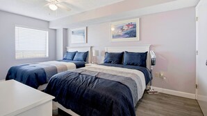 A bedroom with two beds, a ceiling fan, and a painting on the wall. - Beauty on The Beach! (Myrtle Beach)